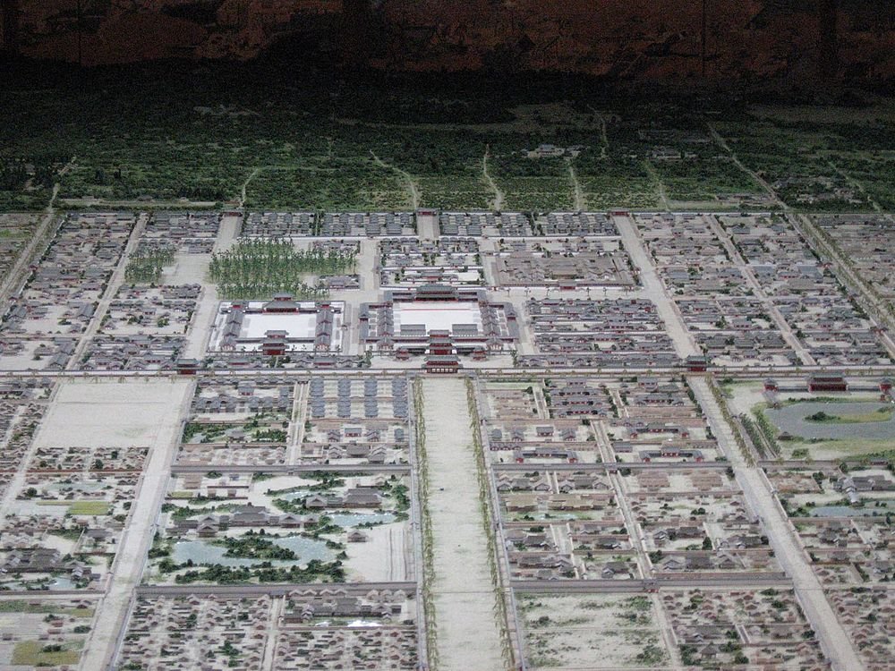 Scale Model of Ancient City Layout Detailed scale model of an ancient city layout with traditional buildings, streets, and greenery, showcasing historical architecture.