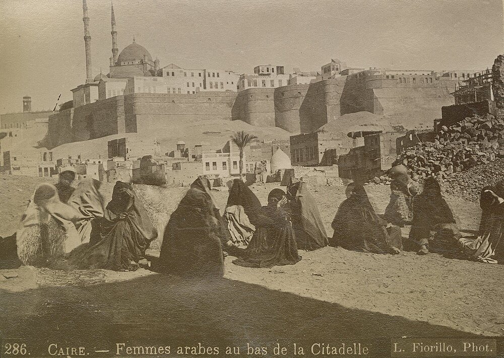 Arab Women Near Cairo Citadel Historic Site Arab women sitting near the base of the Citadel in Cairo with historic buildings and mosque in the background