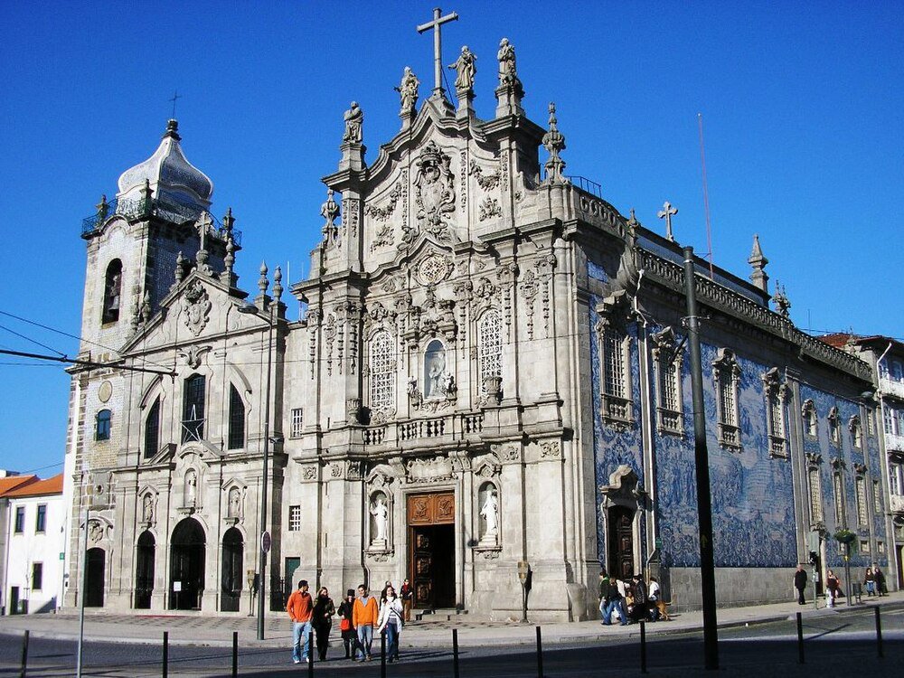 Baroque church with blue tile murals Baroque church with ornate stone facade and blue tile murals under clear blue sky in a European city