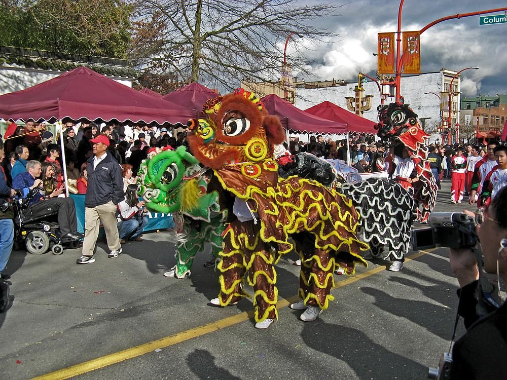 Chinese lion dance at outdoor cultural festival Colorful traditional Chinese lion dance performance at outdoor festival with crowd and tents in background