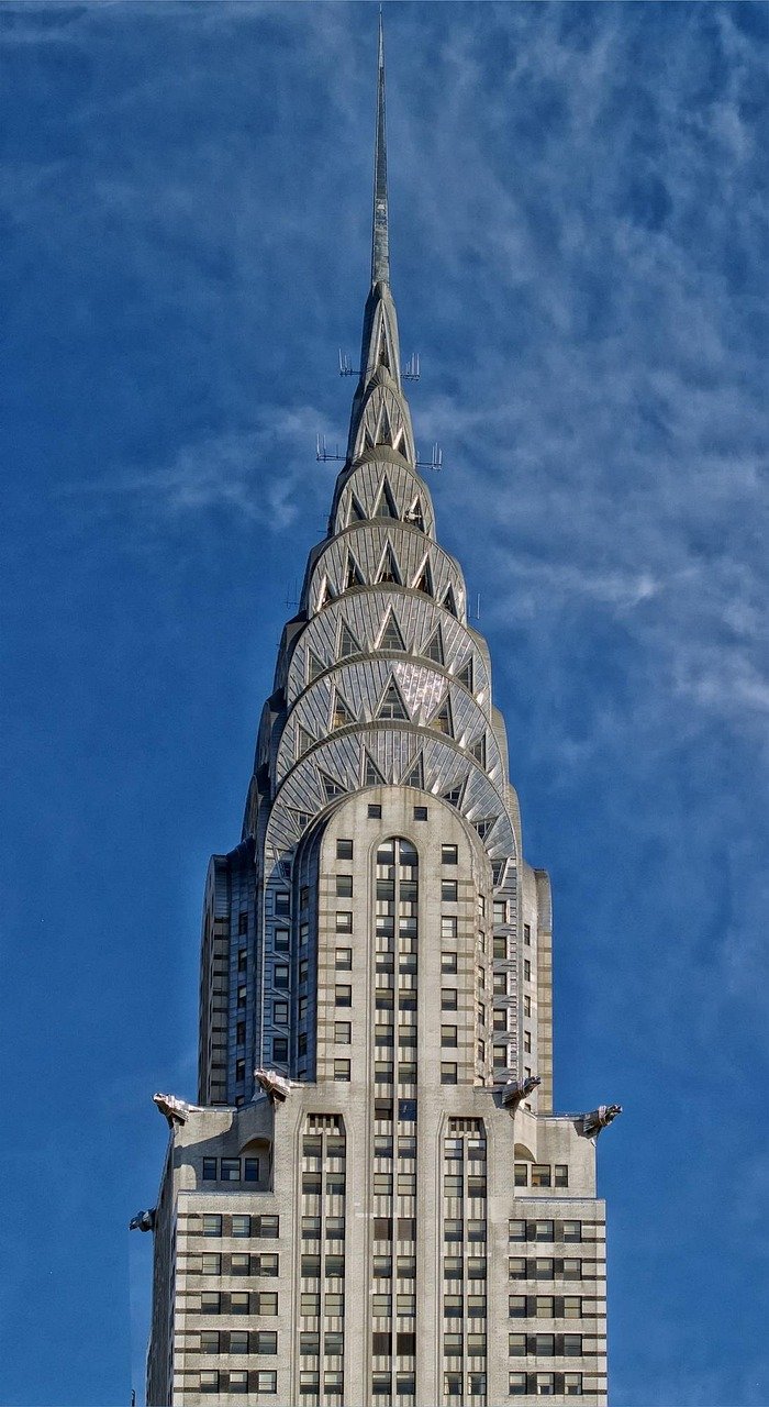 Close-up view of the iconic Chrysler Building spire with its Art Deco architecture against a blue sky