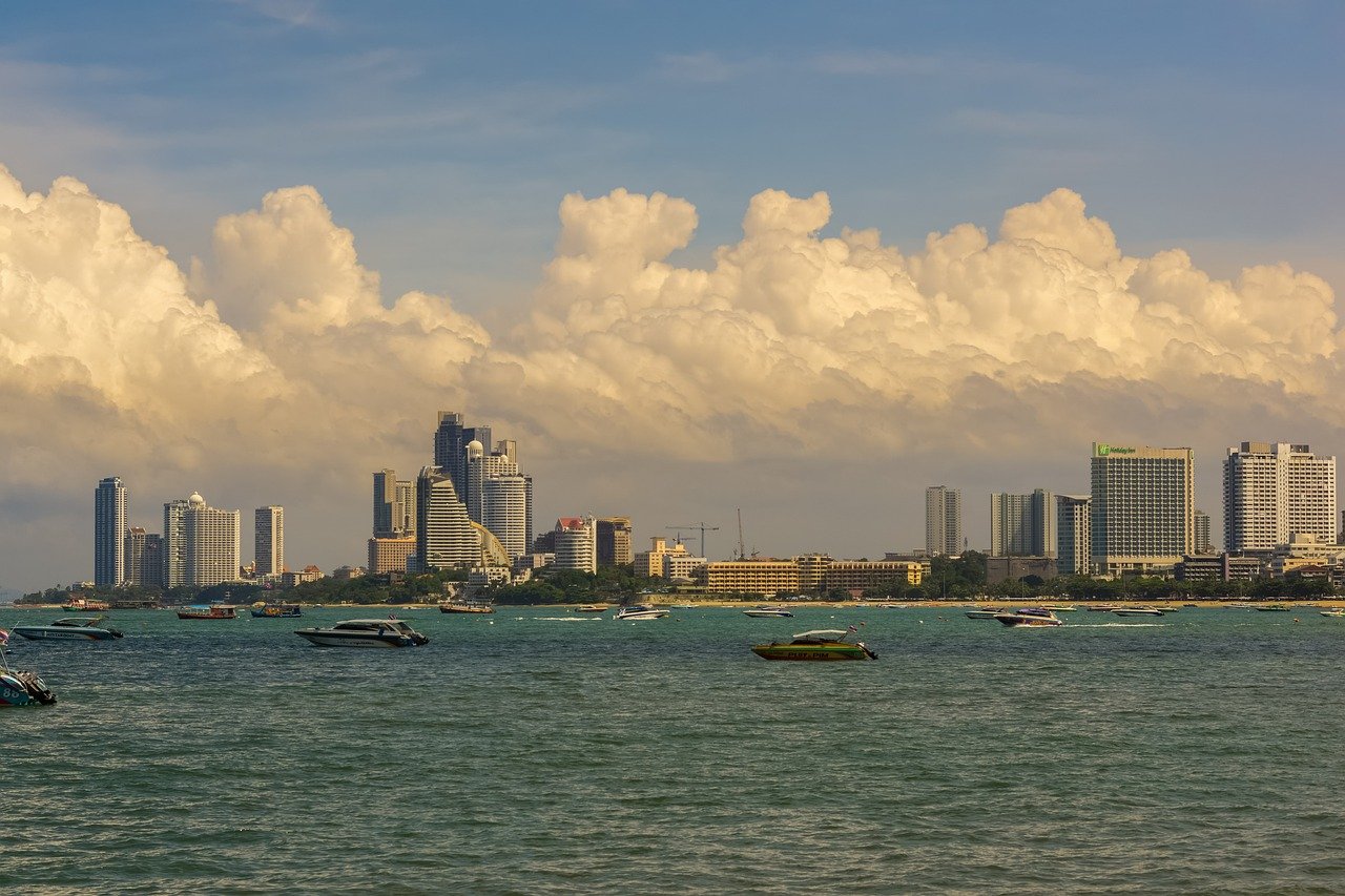 City skyline with high-rise buildings and boats on the water under a cloudy sky during daytime