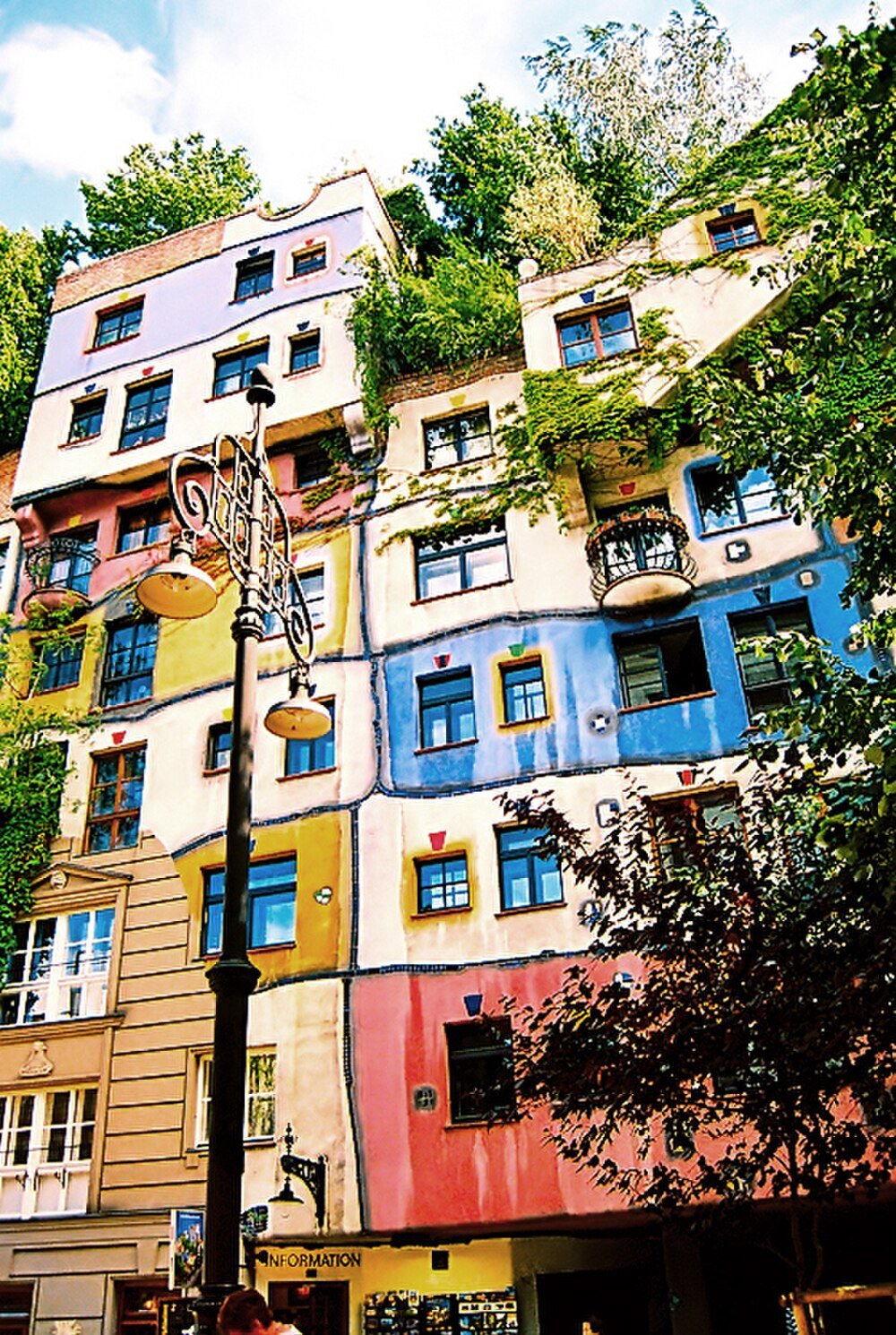 Colorful artistic building facade with plants Colorful artistic building facade with plants and unique window designs in a vibrant urban setting