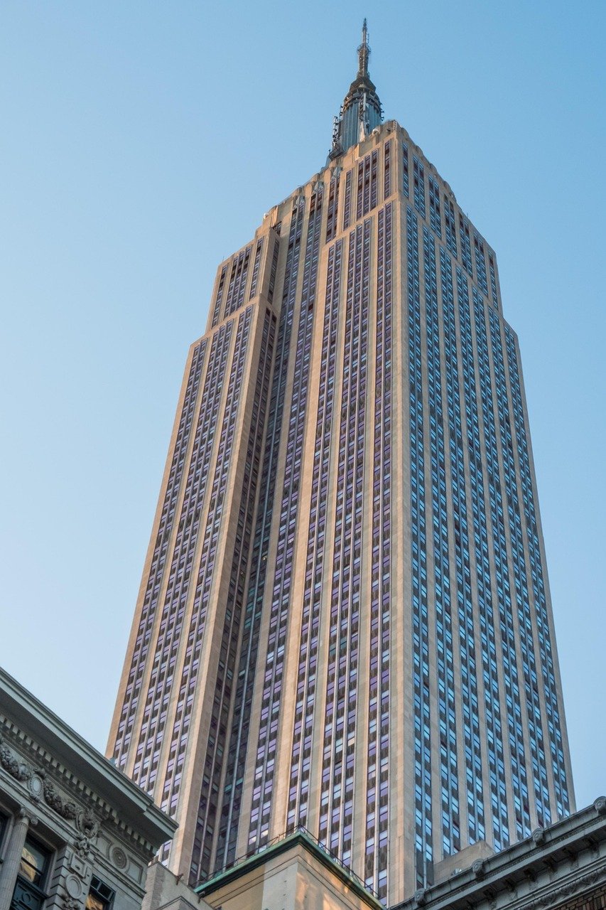 Empire State Building towering against clear blue sky in New York City, iconic skyscraper and architectural landmark.