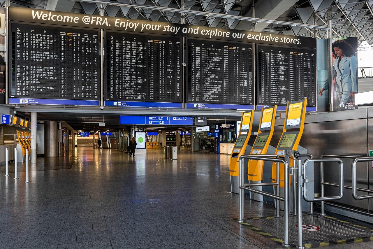 Frankfurt Airport departure hall with flight information boards and self-service check-in kiosks
