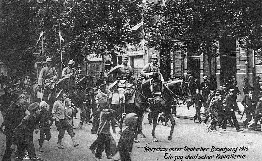 German Cavalry Parade in Warsaw 1915 Black and white photo of German cavalry soldiers on horseback parading through a street in Warsaw during 1915 occupation
