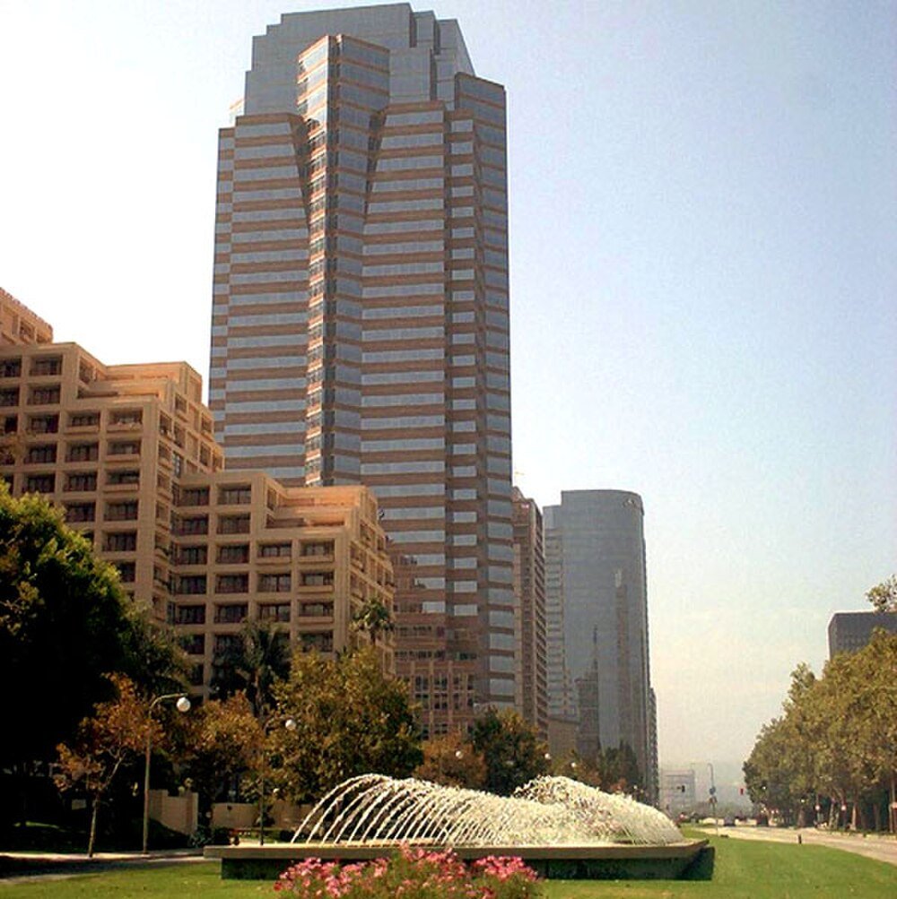 High-rise office buildings with fountain in city park Modern high-rise office buildings with a water fountain and green park area in a sunny urban cityscape