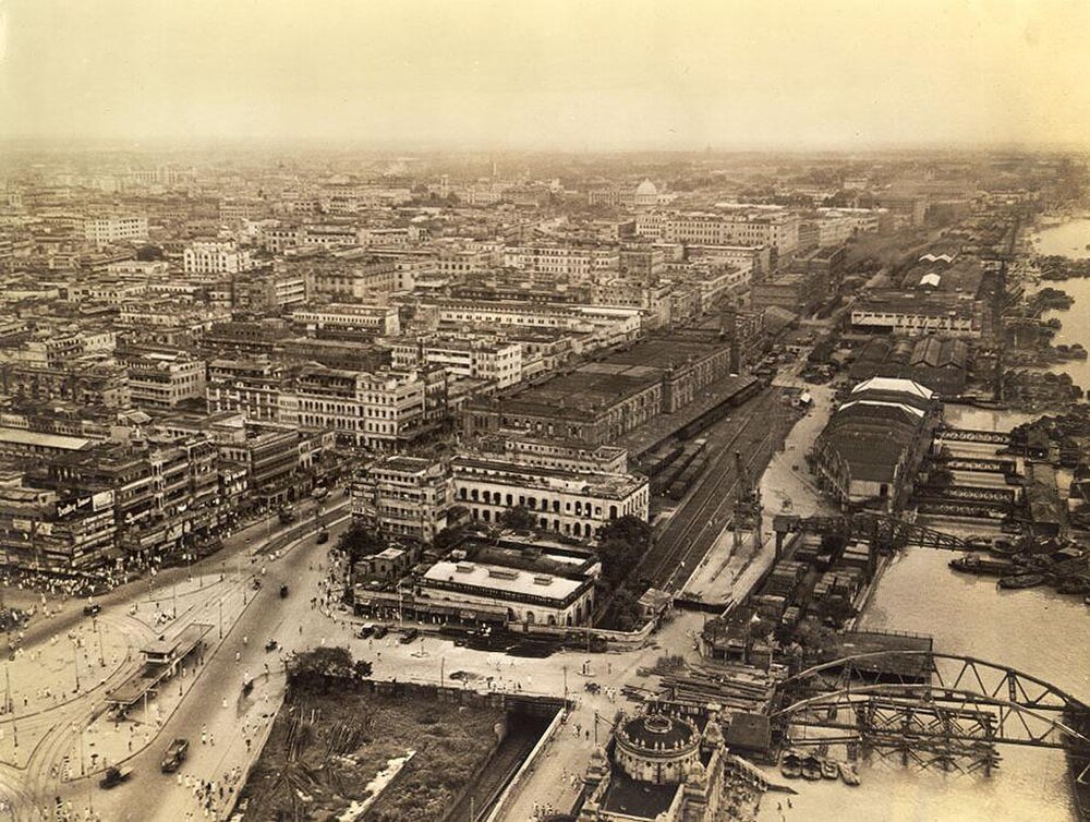 Historic aerial cityscape with river and bridges Aerial view of a historic urban cityscape with dense buildings, roads, and a river with bridges and boats.