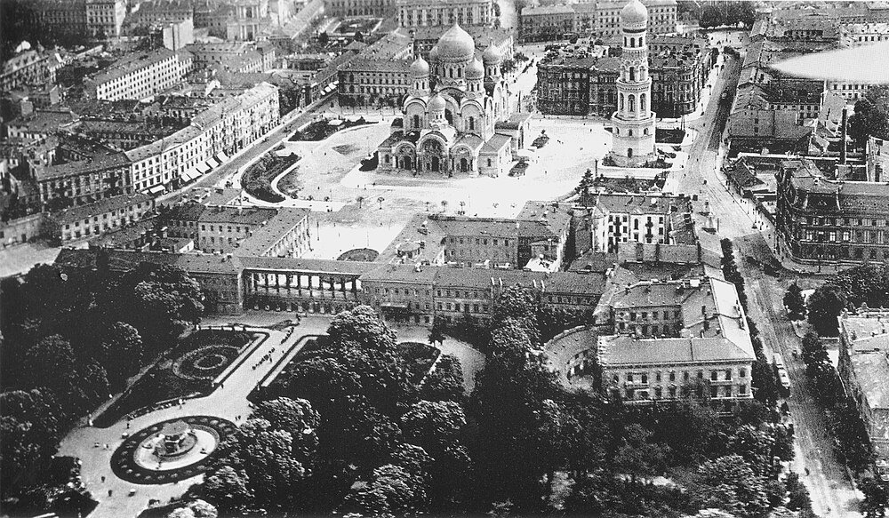 Historic city square with cathedral and bell tower Aerial black and white photo of a historic city square with a large cathedral and bell tower surrounded by buildings and trees