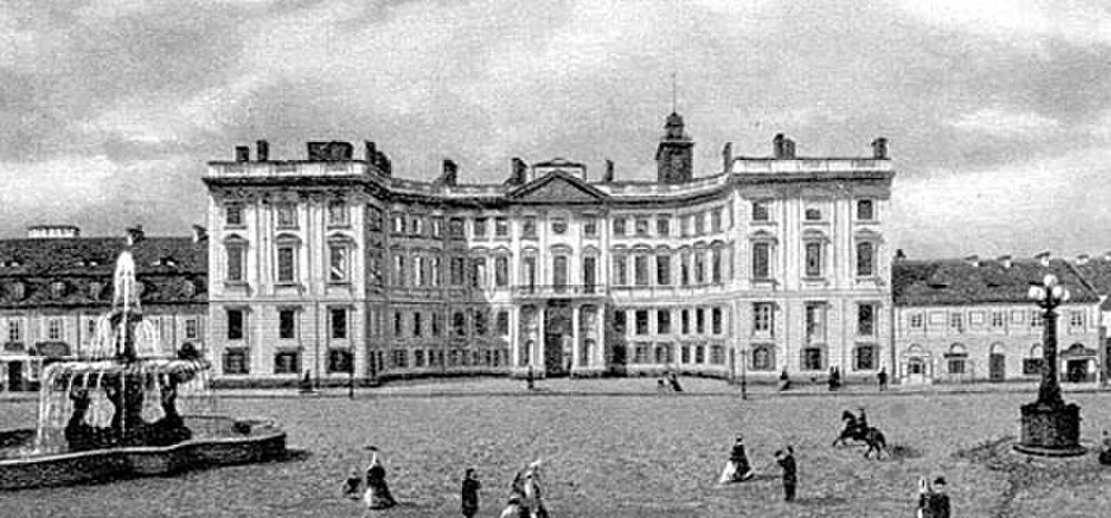 Historic European palace with fountain and people Historic black and white photo of a grand European palace with a fountain and people in period clothing in the square