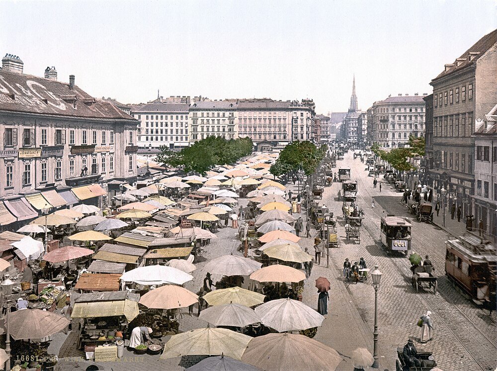 Historic European street market with trams and carriages Historic European street market with colorful umbrellas, horse-drawn carriages, and vintage tram in a bustling city scene