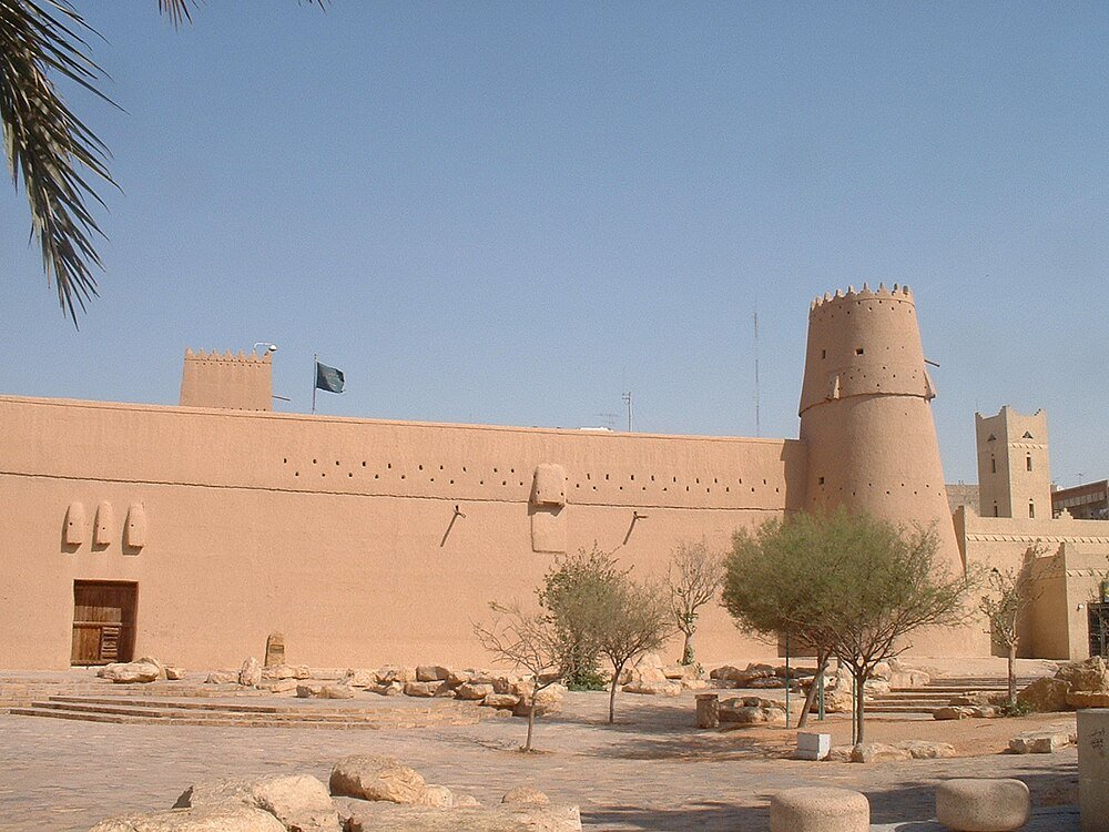 Historic Mud-Brick Fort with Watchtower Historic mud-brick fort with watchtower and trees in desert courtyard under clear blue sky