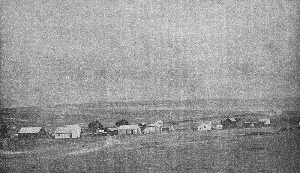 Historic rural farming settlement on flat plains Historic black and white photo of a rural farming settlement with barns and houses on flat plains