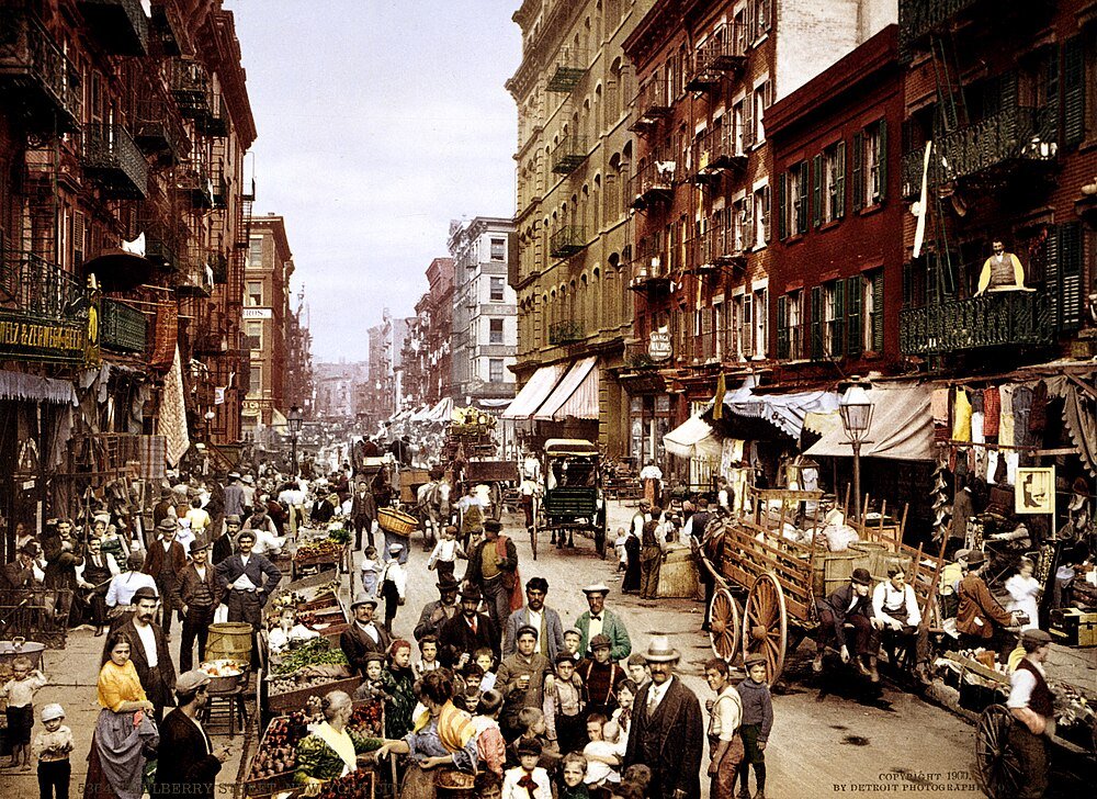 Early 1900s busy urban street market scene Historic crowded street scene with people, horse-drawn carts, and market stalls in early 1900s urban neighborhood
