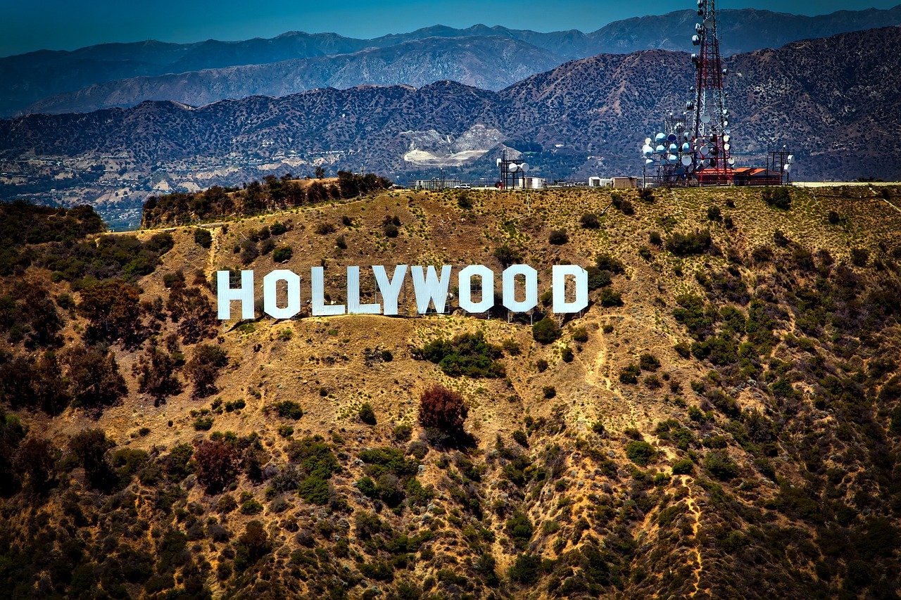 Iconic Hollywood sign on a sunny hillside with mountains in the background, symbolizing the entertainment industry in Los Angeles