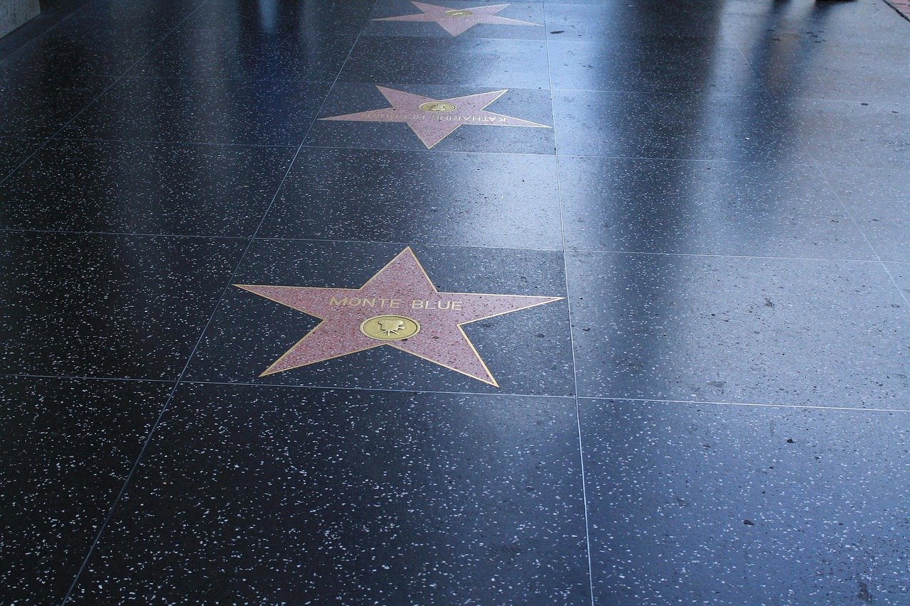 Hollywood Walk of Fame stars on black terrazzo sidewalk honoring Monte Blue and Katharine Hepburn