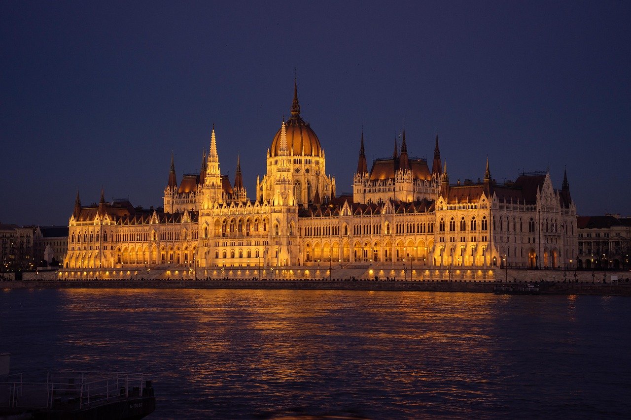Illuminated Hungarian Parliament Building at night reflecting on the Danube River in Budapest, Hungary
