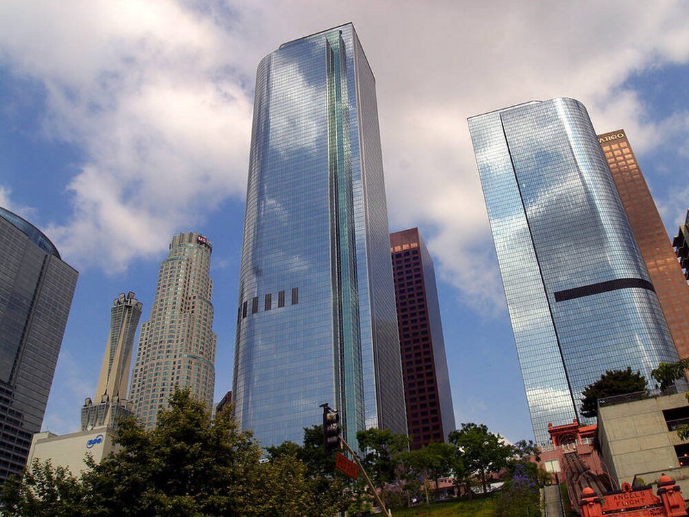 Downtown Los Angeles modern skyscrapers skyline Downtown Los Angeles skyline featuring modern glass skyscrapers under a partly cloudy sky with trees in foreground