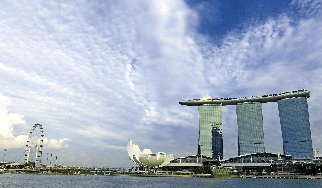 Marina Bay Sands hotel and Singapore Flyer ferris wheel with cloudy sky over Marina Bay waterfront