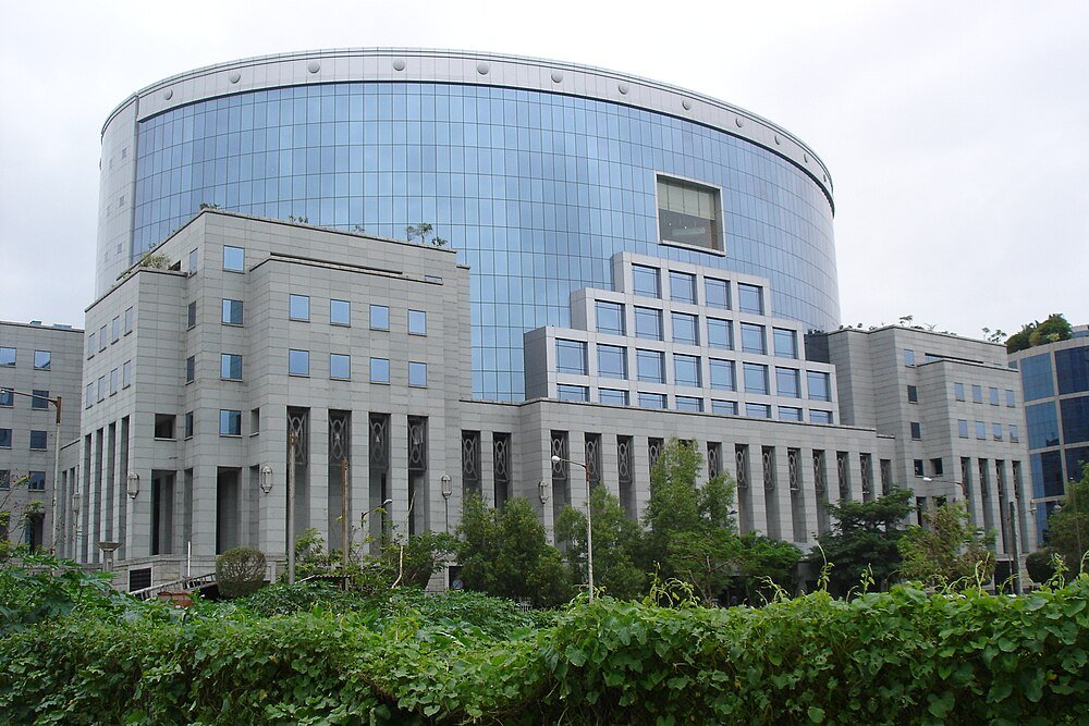 Modern government building with glass facade Modern government building with glass facade and greenery in front, showcasing contemporary architecture in an urban setting