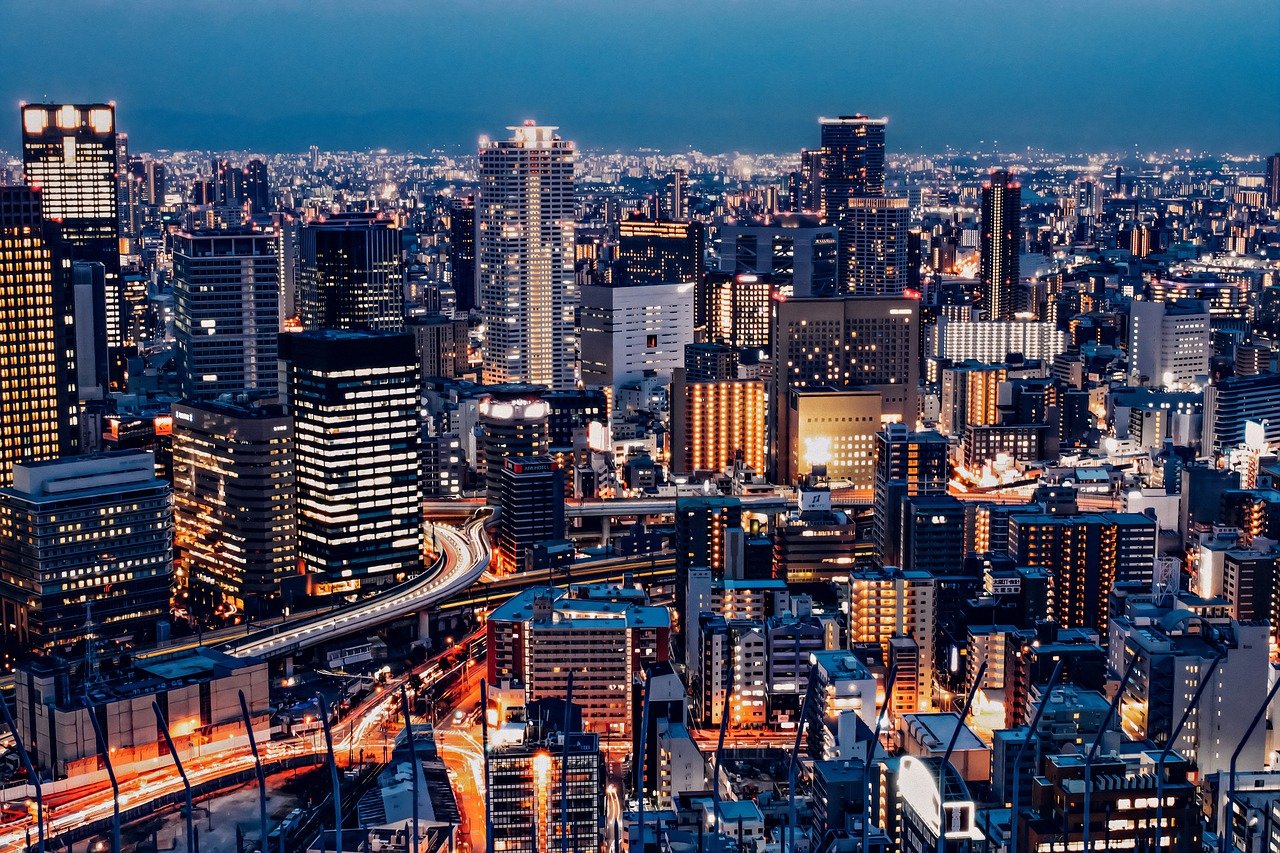 Nighttime cityscape with illuminated skyscrapers and busy highways showcasing urban architecture and vibrant city lights
