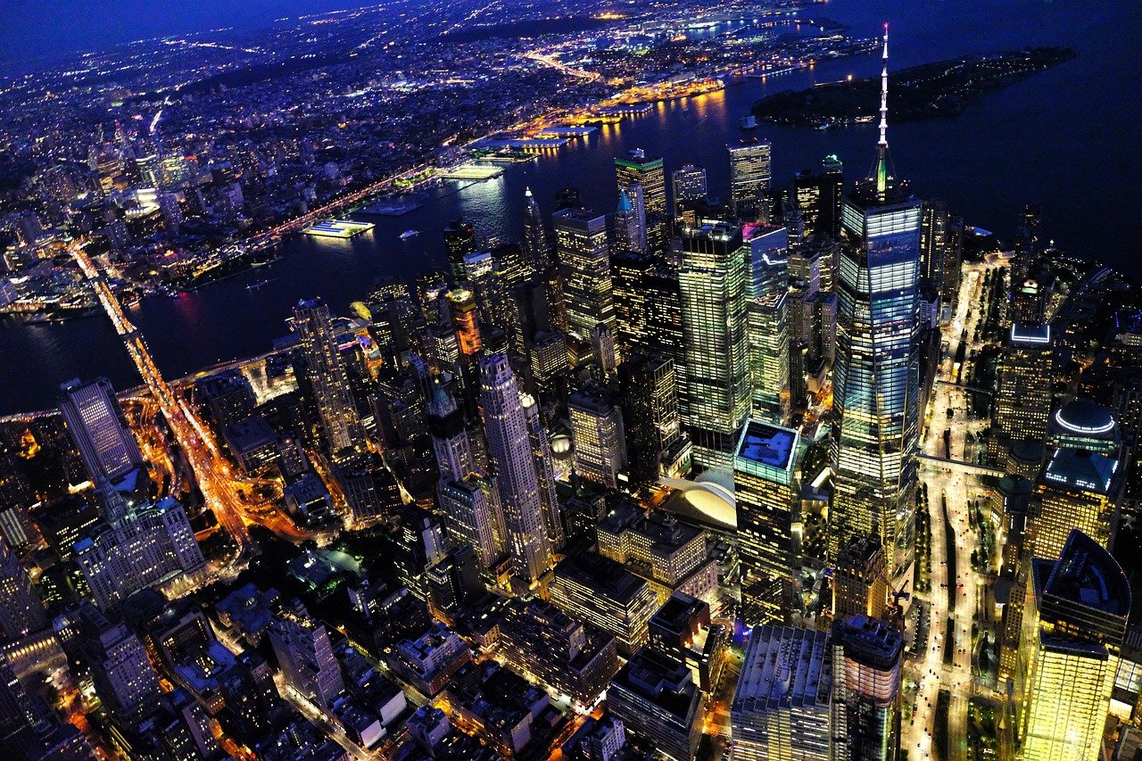 Aerial night view of New York City skyline with illuminated skyscrapers and bridges over the Hudson River