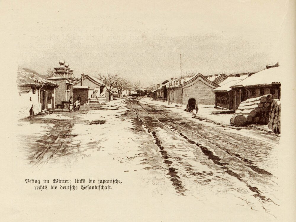 Winter street with Japanese and German embassies in Peking Winter street scene in Peking showing Japanese and German embassy buildings with snow-covered road and stacked logs