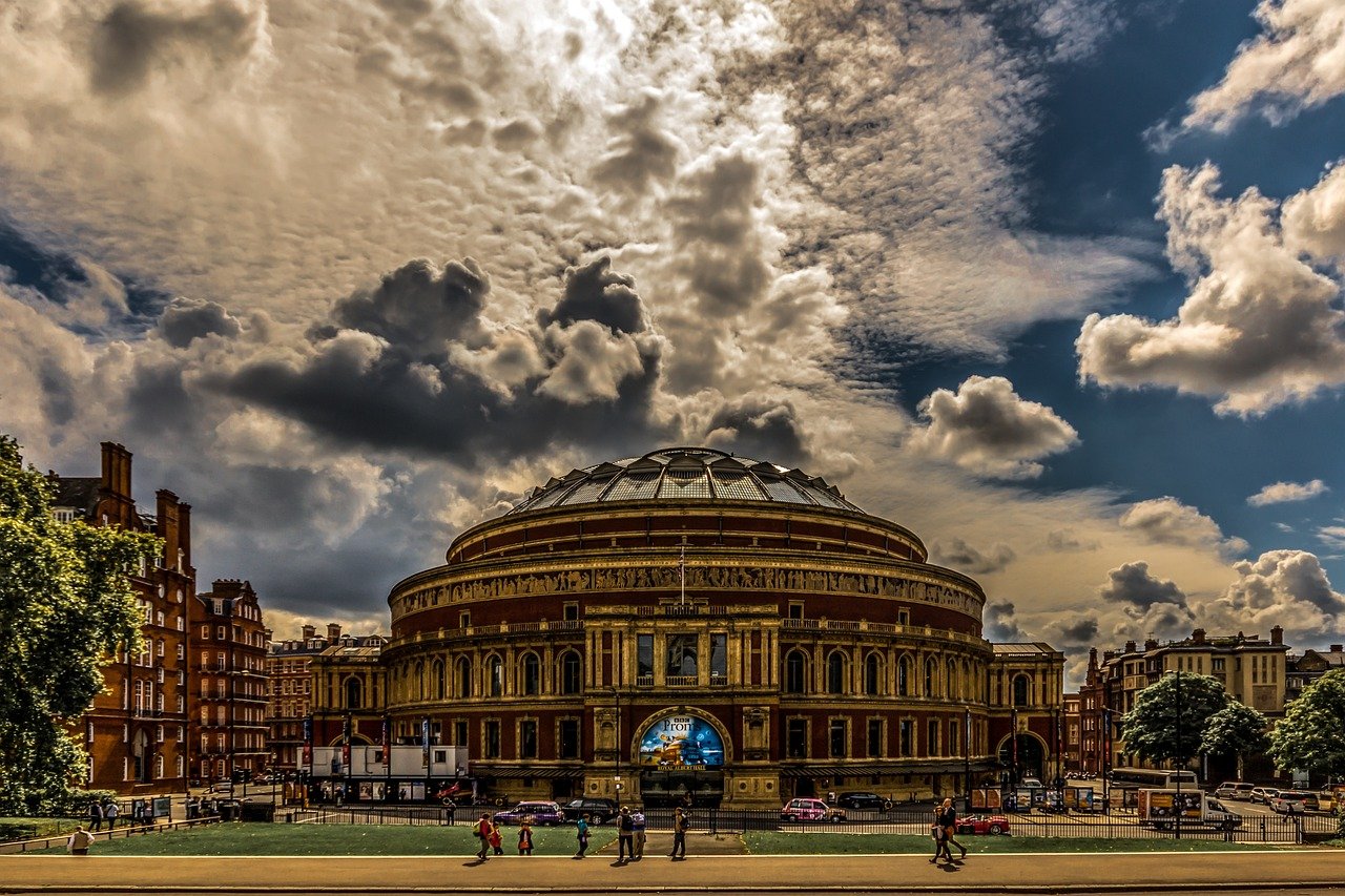 Royal Albert Hall in London with dramatic cloudy sky and people walking in front, historic concert venue and landmark