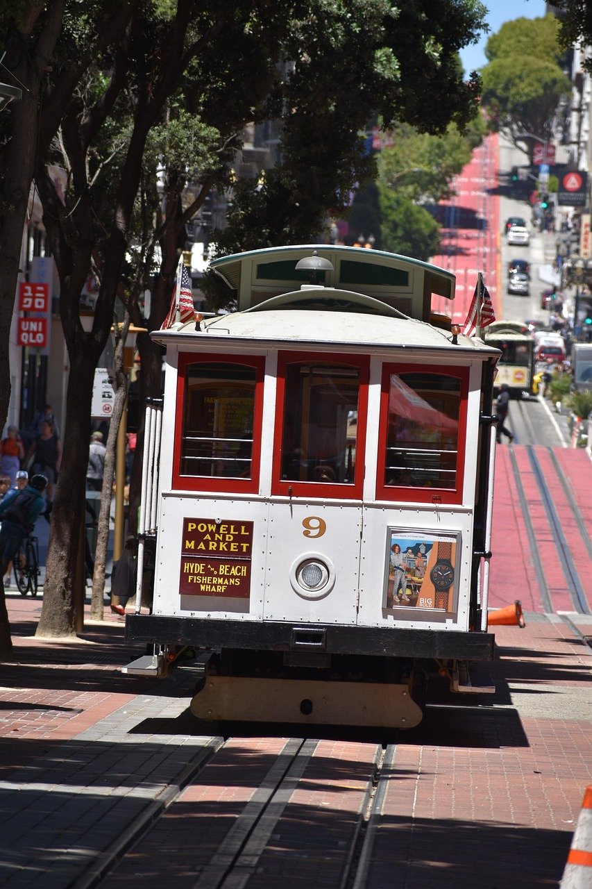 San Francisco cable car number 9 on Powell and Market line with trees and city street in background