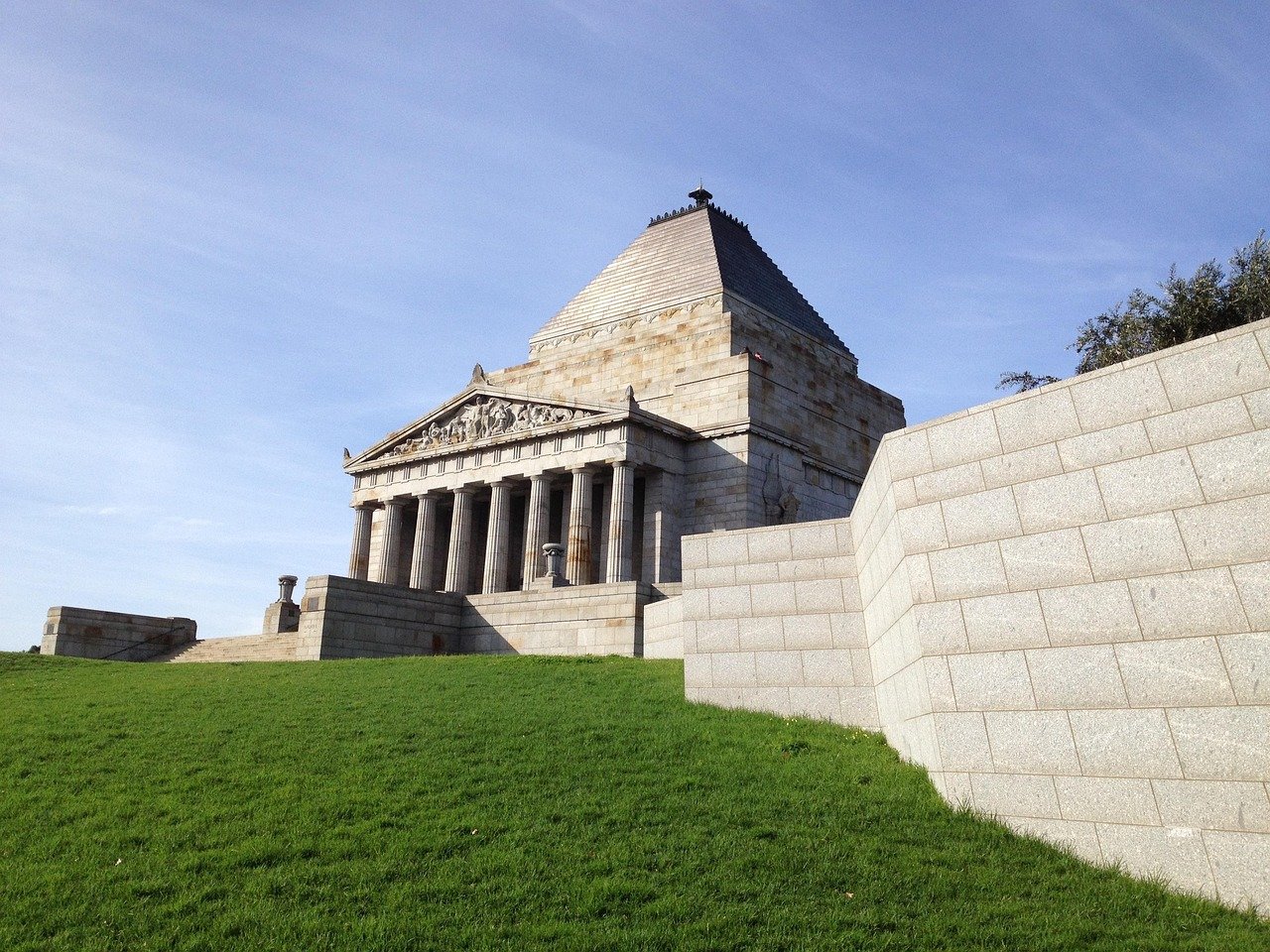 Shrine of Remembrance war memorial with classical architecture and green lawn under clear blue sky