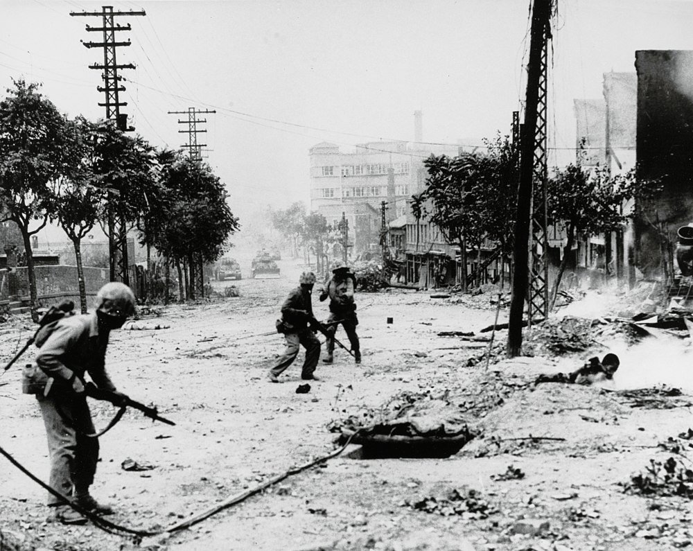 Soldiers in urban combat on war-torn street Black and white photo of soldiers engaged in urban combat on a war-torn street with damaged buildings and military vehicles