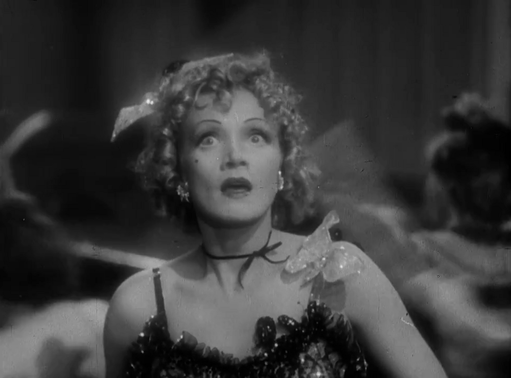 Surprised woman in vintage dress black and white Black and white image of a surprised woman with curly hair wearing a vintage dress and accessories in a classic film scene