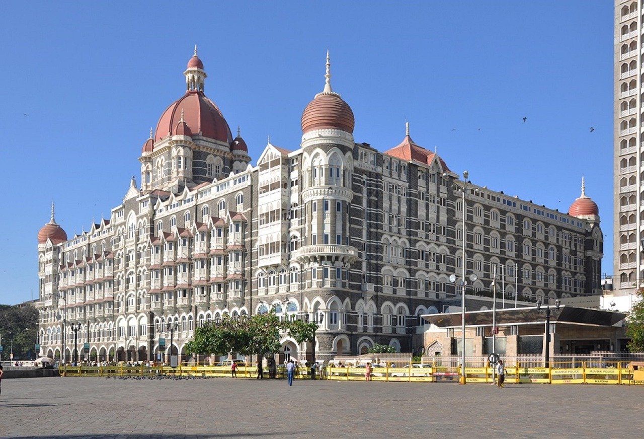 The iconic Taj Mahal Palace Hotel in Mumbai with its distinctive domes and colonial architecture under a clear blue sky