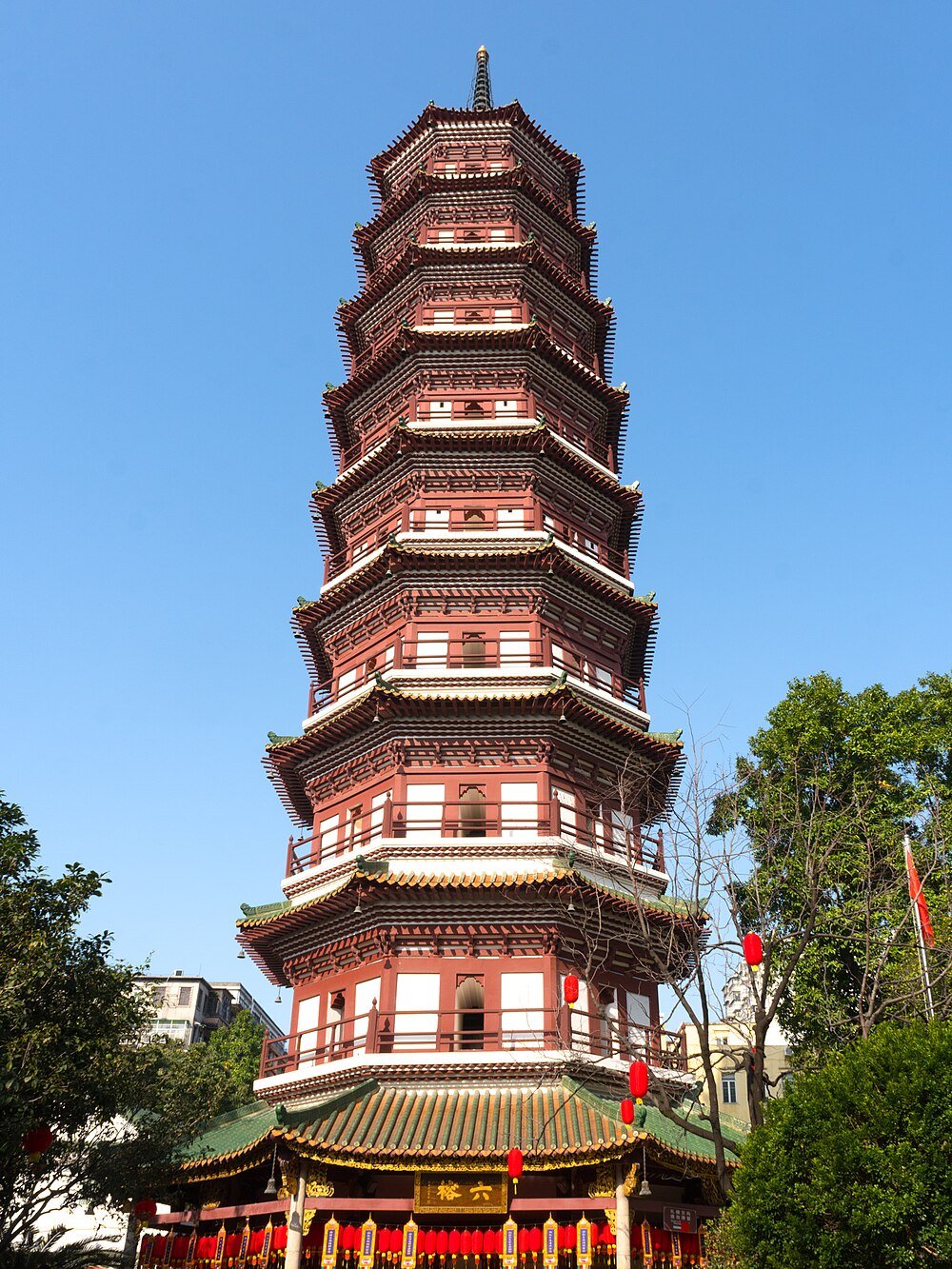 Traditional Chinese pagoda tower with multiple tiers and ornate roof details under clear blue sky