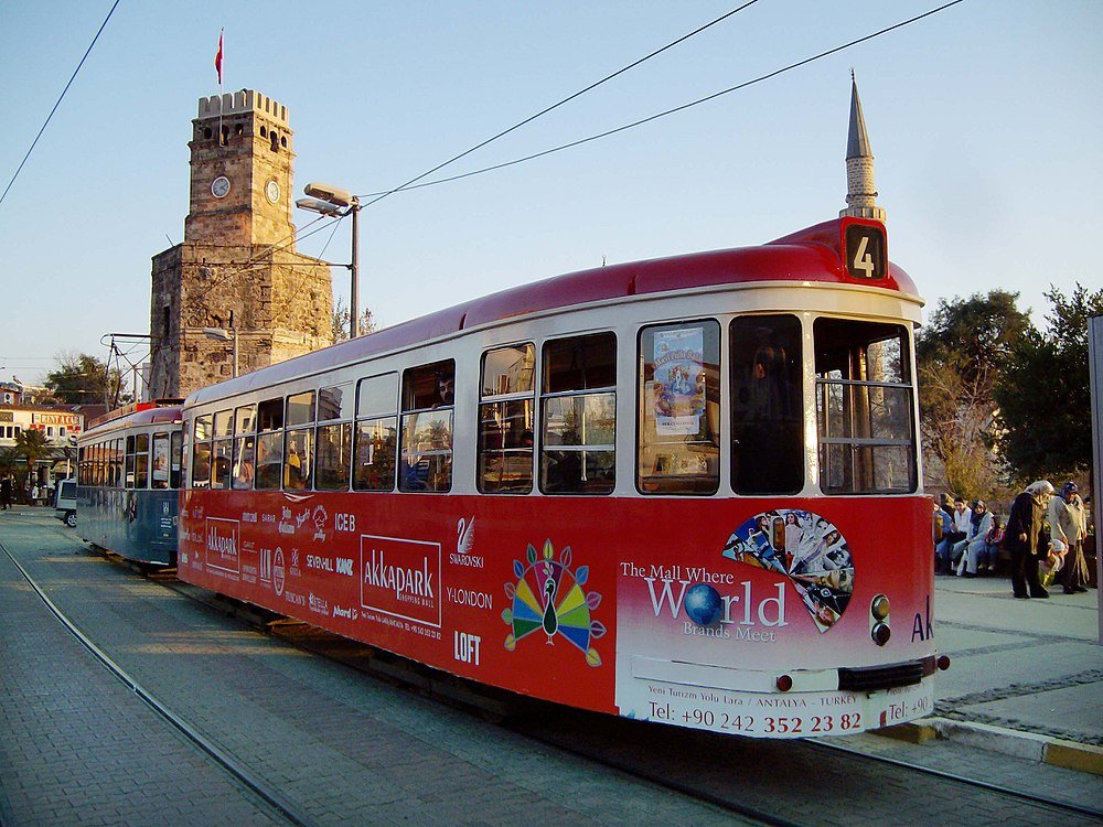 Tram number 4 near clock tower in Antalya, Turkey Red and white tram number 4 at a station with historic clock tower and Turkish flag in Antalya, Turkey