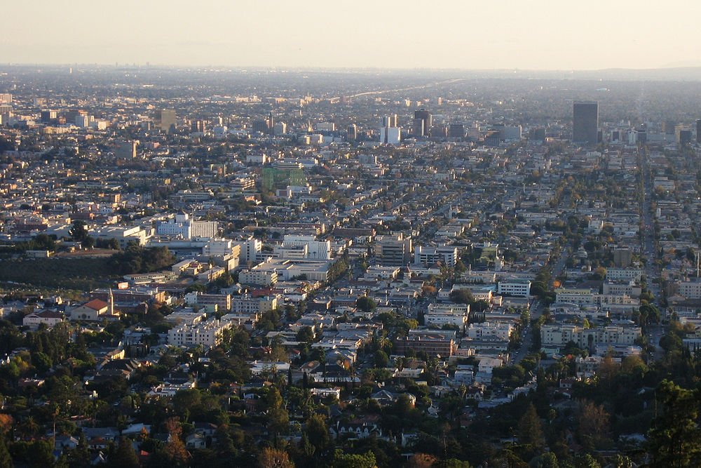 Urban cityscape aerial view at sunset Aerial view of a sprawling urban cityscape with dense buildings and streets under a clear sky at sunset