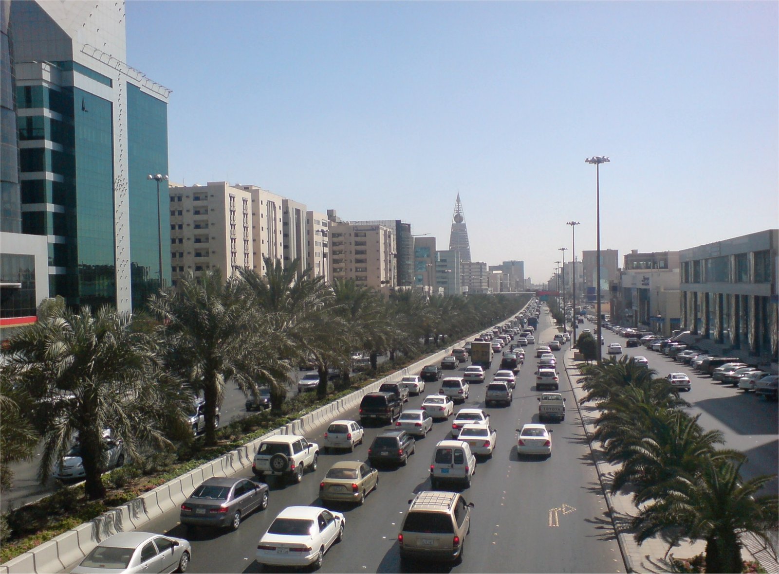 Busy urban highway with traffic and palm trees Heavy traffic on a busy urban highway lined with palm trees and modern buildings under a clear blue sky