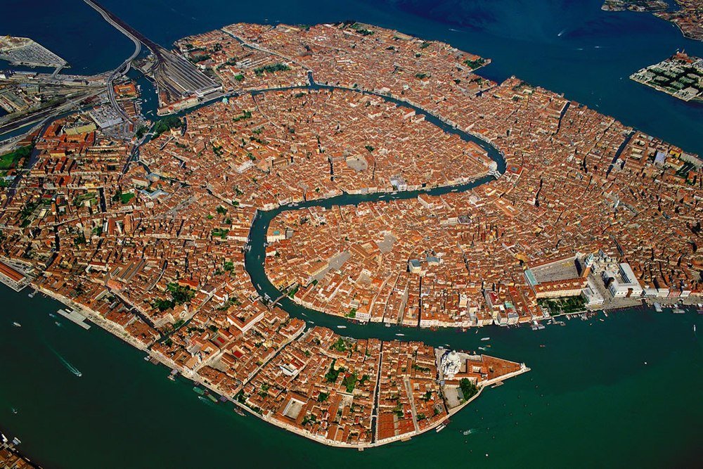 Aerial view of Venice Italy showing historic buildings and canals surrounded by water, highlighting the city's unique architecture.