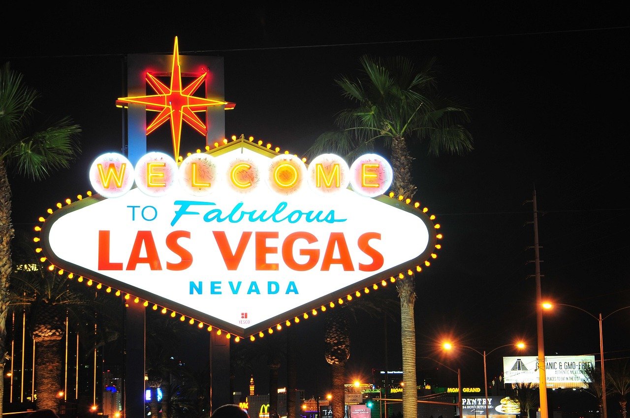 Iconic Welcome to Fabulous Las Vegas Nevada neon sign at night with palm trees and city lights in background