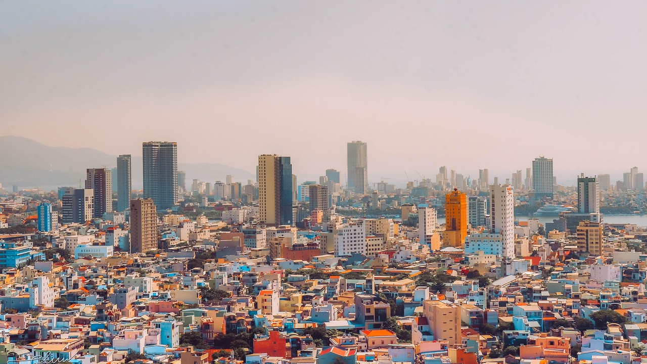 Cityscape with colorful buildings and skyscrapers Panoramic view of a densely populated city with colorful buildings and modern skyscrapers under a hazy sky