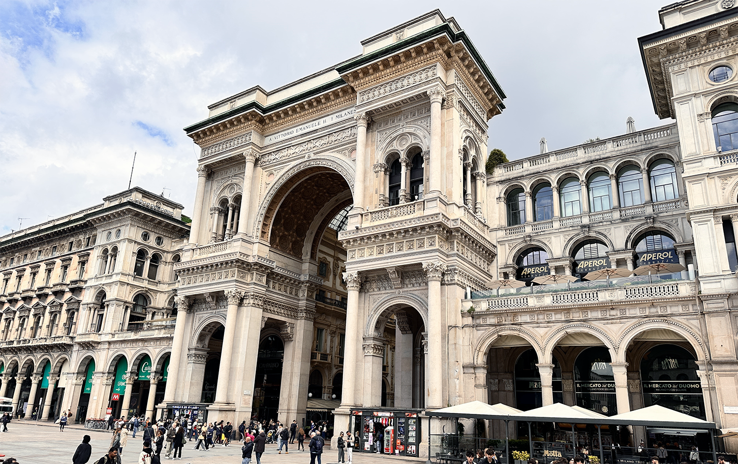Galleria Vittorio Emanuele II Milan Archway Historic Galleria Vittorio Emanuele II archway and shopping arcade in Milan with tourists and outdoor cafes