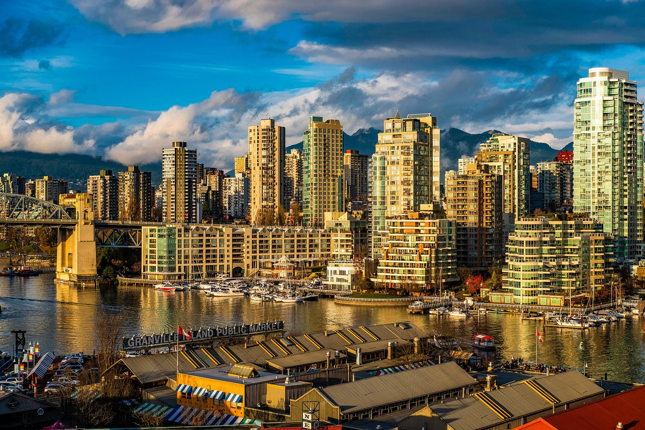 Granville Island Public Market and Vancouver Waterfront Granville Island Public Market with waterfront high-rise buildings and boats in Vancouver cityscape under blue sky