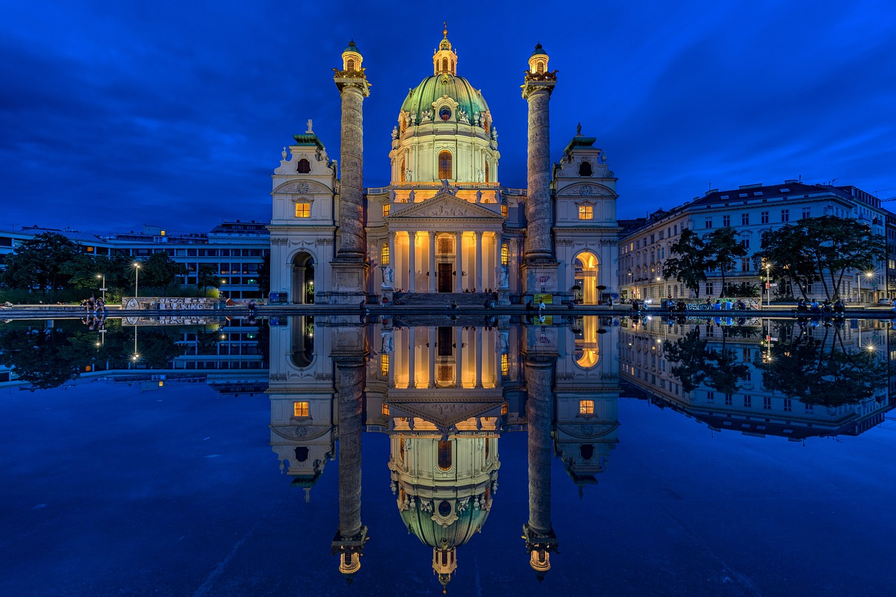 Historic illuminated church at twilight with reflection Illuminated historic church with twin columns reflected in water at twilight in a European city