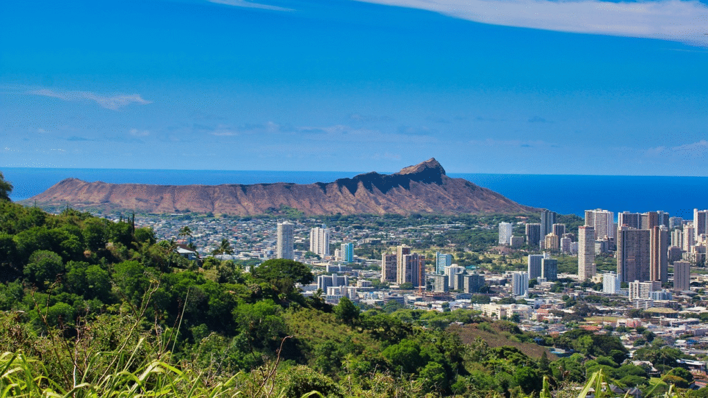 Panoramic view of Honolulu's skyline with Diamond Head crater in the background and the turquoise Pacific Ocean stretching toward Waikiki Beach