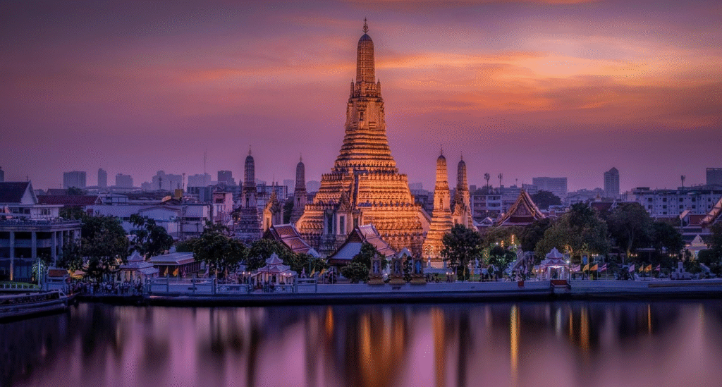 Wat Arun temple at sunset with vibrant purple and orange sky reflecting on the Chao Phraya River in Bangkok, Thailand