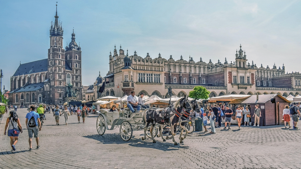 Historic Krakow city square with horse-drawn carriages