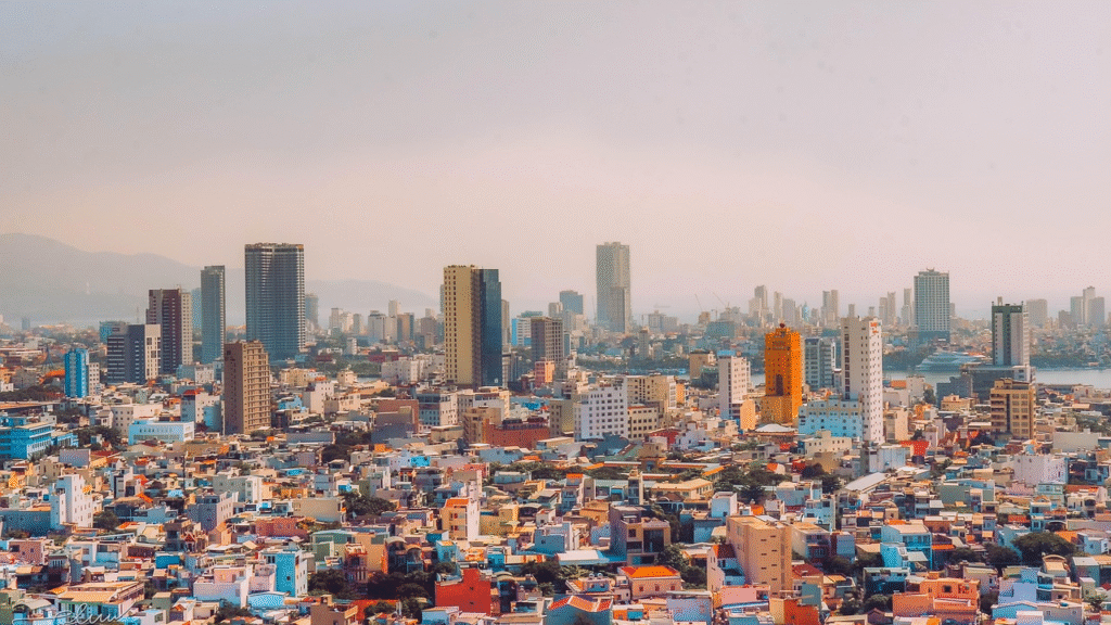 Panoramic view of Da Nang at dusk — the curved Han River cutting through the city with the iconic Dragon Bridge and modern skyscrapers reflecting in the water