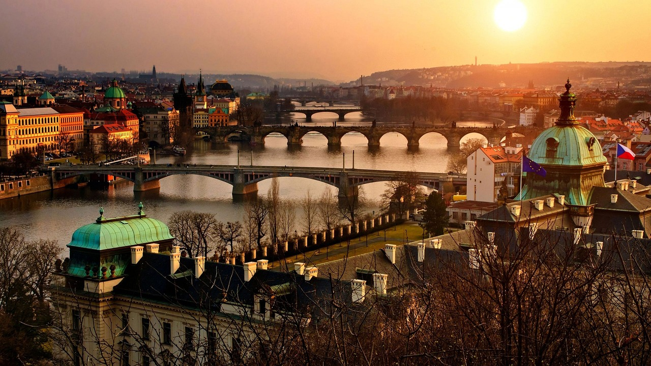 Prague cityscape with Vltava River and bridges at sunset Scenic view of Prague city with Vltava River and historic bridges at sunset, featuring iconic architecture and warm lighting