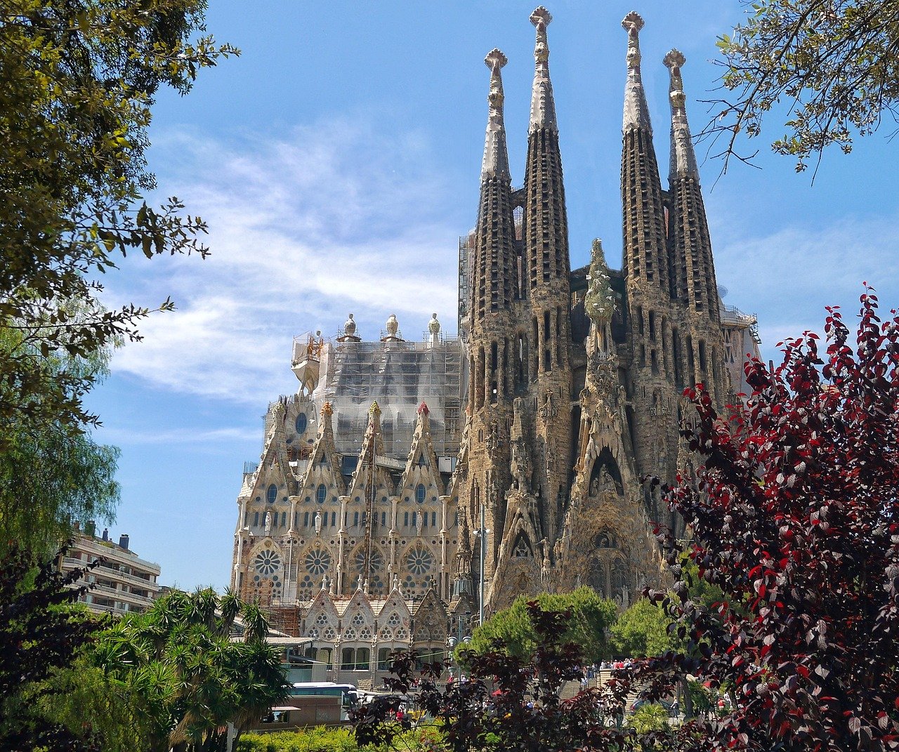 The Sagrada Familia basilica in Barcelona, Spain, showcasing its intricate Gothic and Art Nouveau architecture under a clear blue sky.