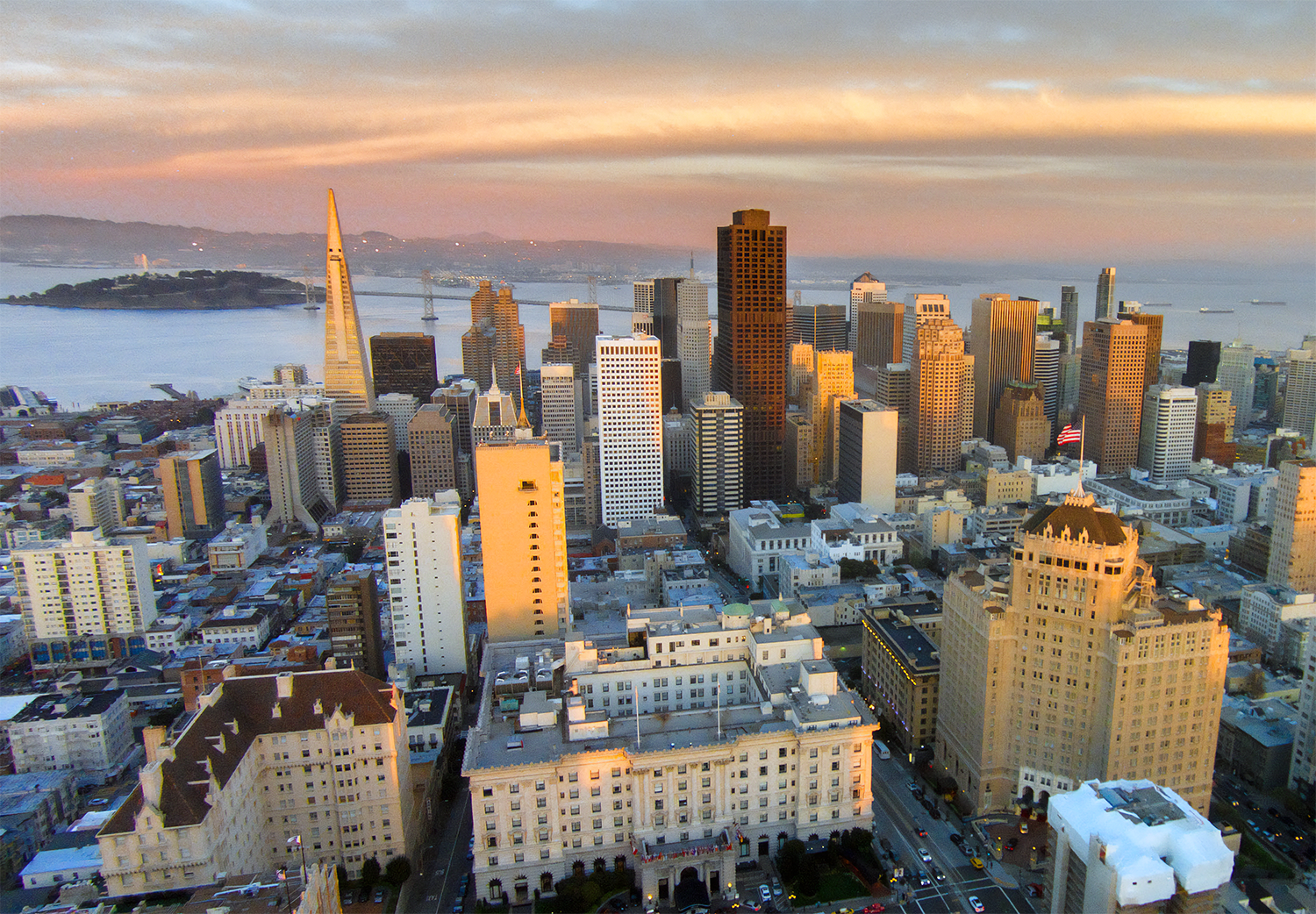 San Francisco skyline with Transamerica Pyramid at sunset Aerial view of San Francisco skyline at sunset with iconic Transamerica Pyramid and Bay Bridge in the background